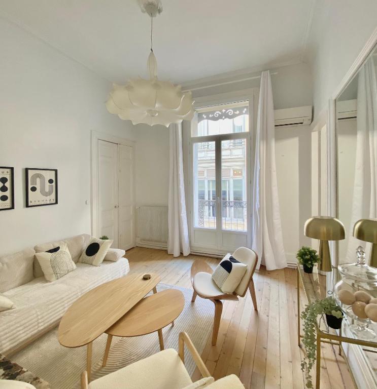 un salon avec un canapé et une table dans l'établissement Le temps d'un passage, appartement de charme en plein centre historique, à Montpellier