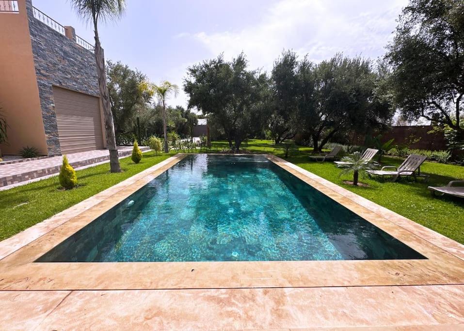 マラケシュにあるVilla Kamélia 5000m Hammam Piscine Chauffée et Sans Vis à Visの家の庭にあるプール