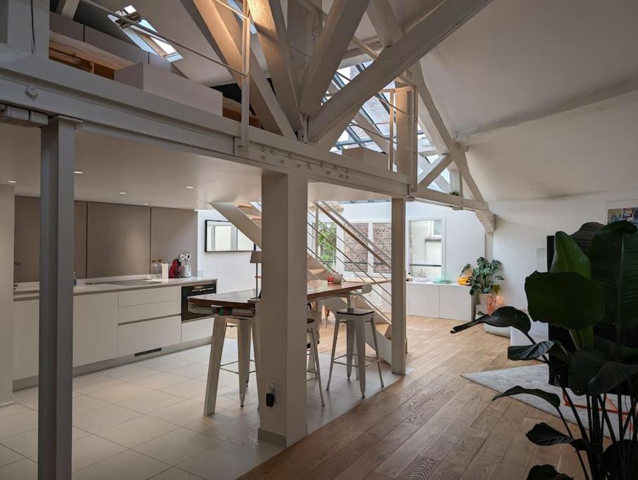 une cuisine et une salle à manger avec une table et des chaises dans l'établissement R'Apparts T3 Montreuil Sky Loft, à Montreuil