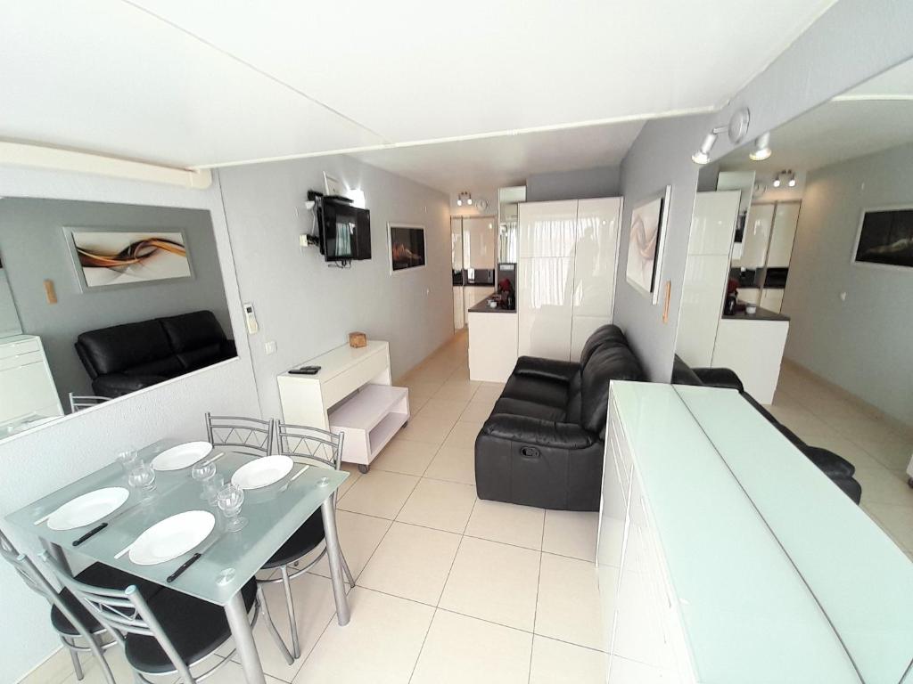 un salon avec une table et un canapé dans l'établissement Appartement Village Naturiste Tentation, au Cap d'Agde