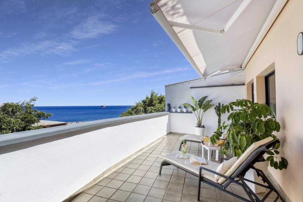 Un balcón con una silla y vistas al océano. en Roof With Terrace, en San Andrés