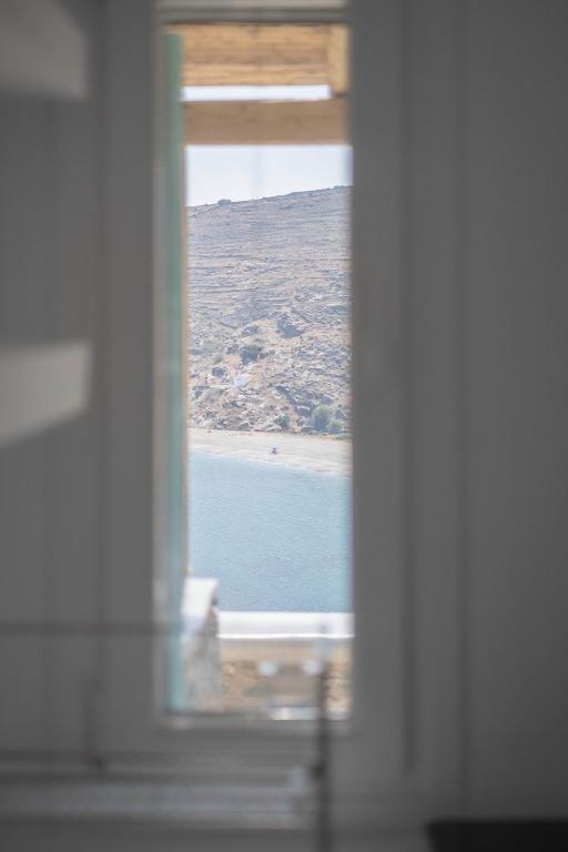 a view of a beach from a window at Kyon Beach Suites Kythnos in Kanala