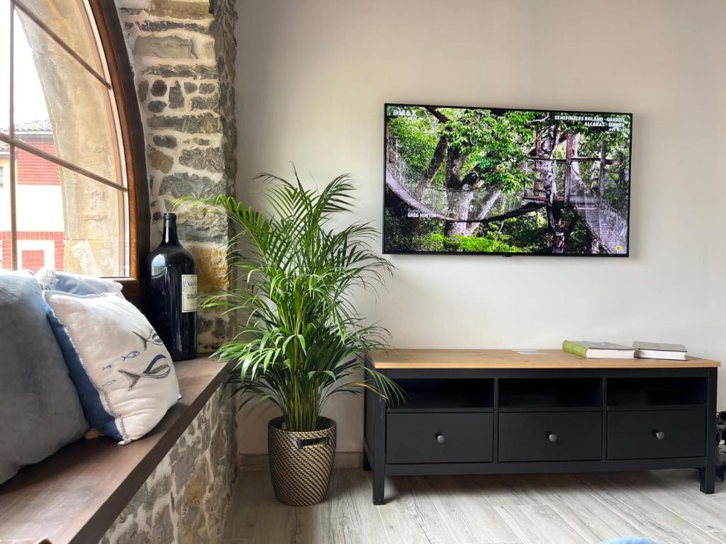 a bedroom with a table and a plant on a wall at Apartamentos BuenaVista in Colunga