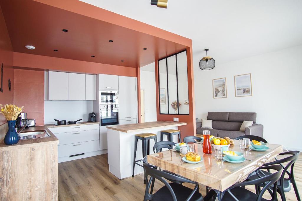 une cuisine et une salle à manger avec une table et des chaises dans l'établissement -IRIS- Magnifique T2 renove avec balcon et parking, à Concarneau