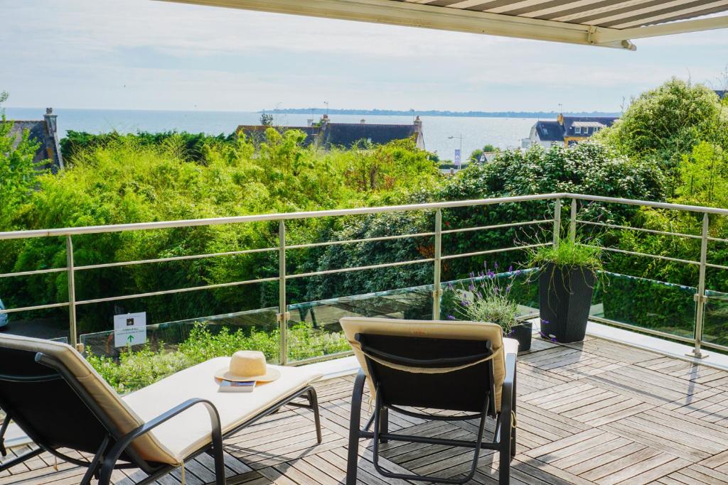 un patio avec des chaises et une table sur un balcon dans l'établissement -La Terrasse- T2 avec Terrasse vue mer, à Concarneau