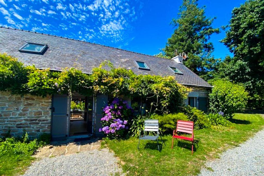 deux chaises assises devant une maison dans l'établissement -PETREL- Maison de campagne avec grand jardin, à Concarneau
