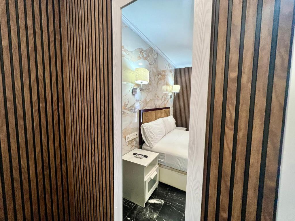małą sypialnię z łóżkiem i lustrem w obiekcie Boutique Princesa w Marbelli
