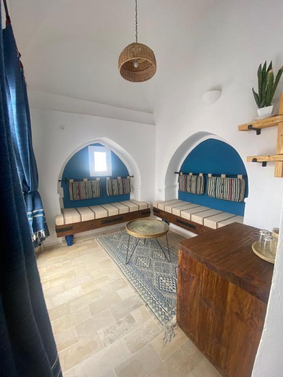 a living room with two benches and a table at Hôtel Djerba Authentique - Au centre de Midoun in Midoun