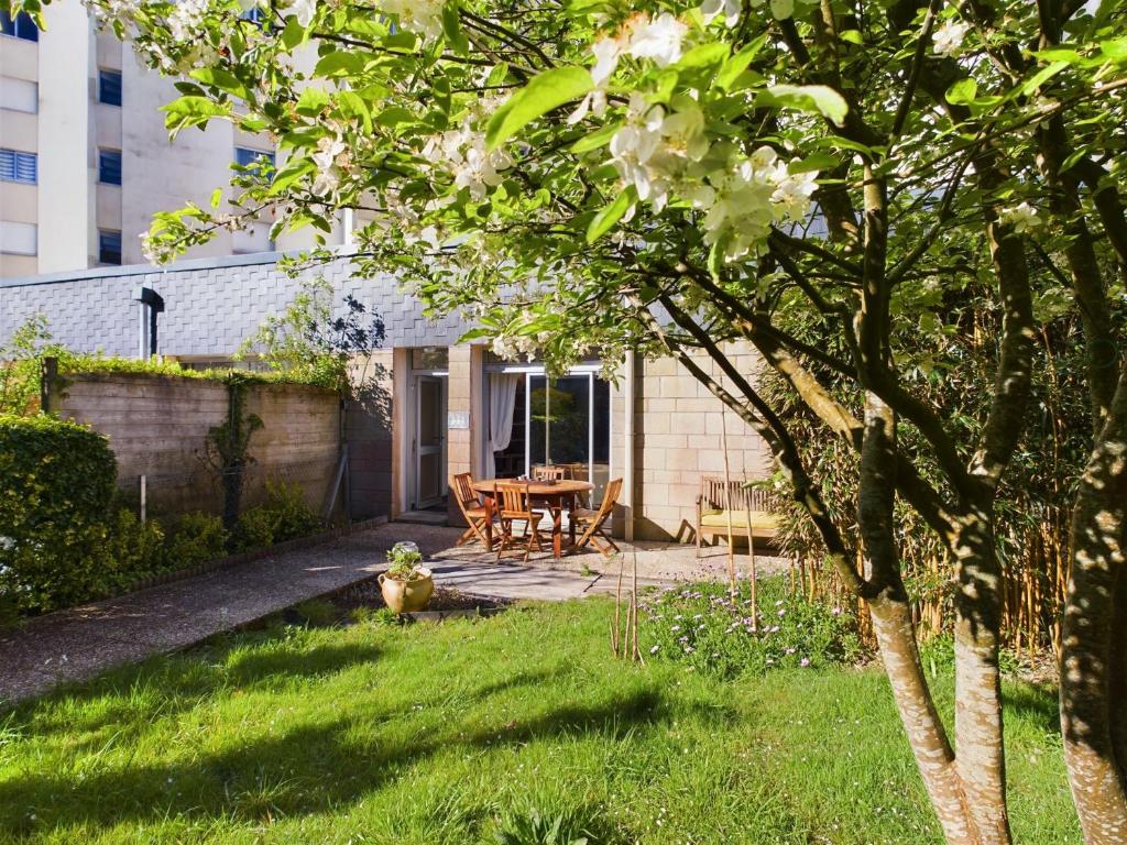 une arrière-cour avec une table en bois et une table de pique-nique dans l'établissement -Palerme- Spacieux appartement proche bord de mer, à Concarneau