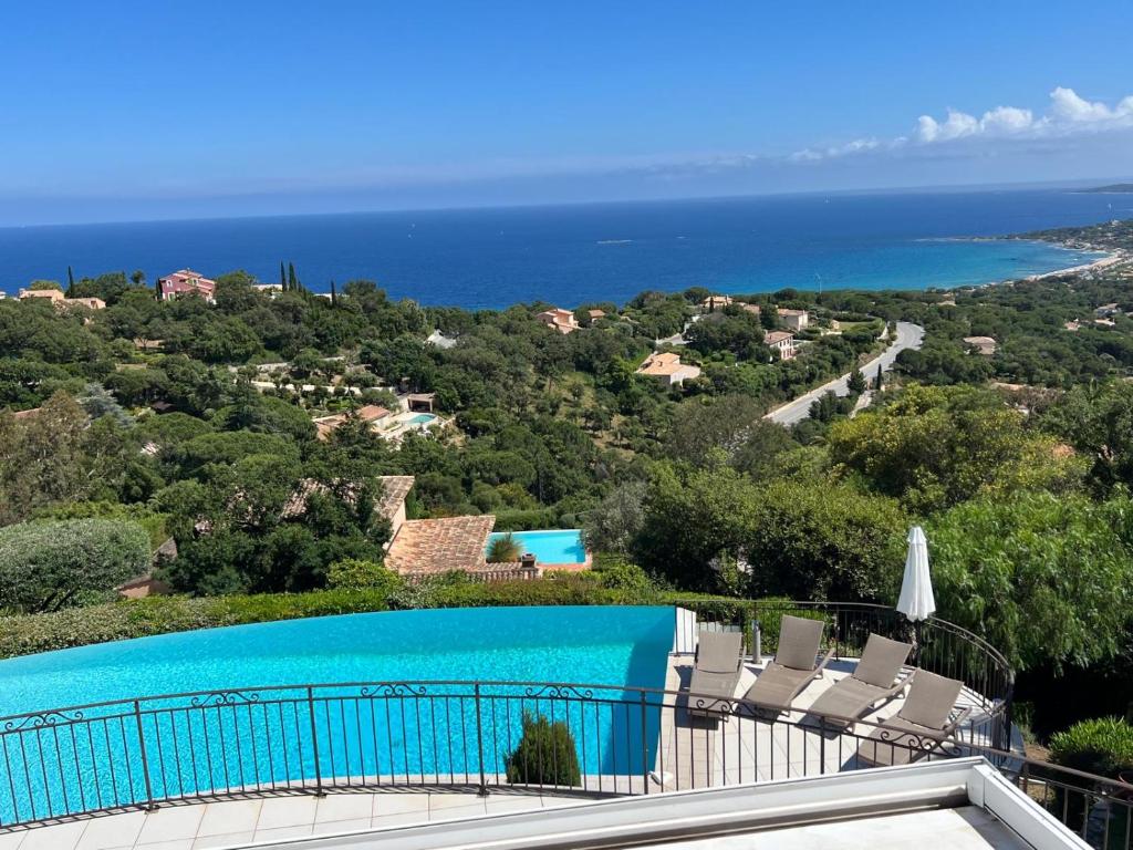 - une vue sur la piscine avec des chaises et l'océan dans l'établissement Villa Vue Mer Exceptionnelle 5 Chambres, à Sainte-Maxime