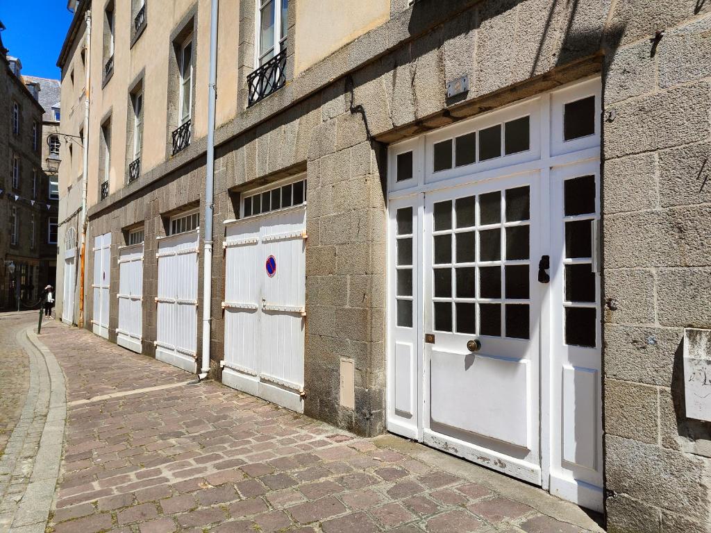 Une rangée de portes blanches de garage sur un bâtiment en briques dans l'établissement L'Asfeld, à Saint-Malo