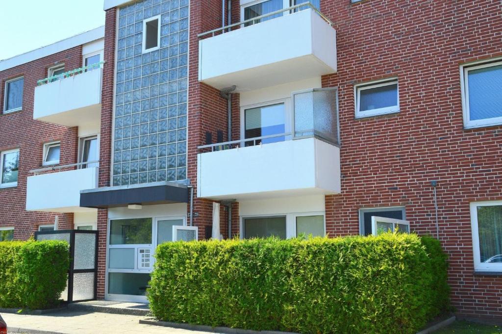 een appartementencomplex met struiken ervoor bij Berliner Ring - Whg 27 in Wyk auf Föhr