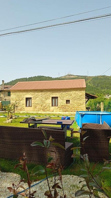 a picnic table and chairs in front of a building at El nido del cuco in Padrón