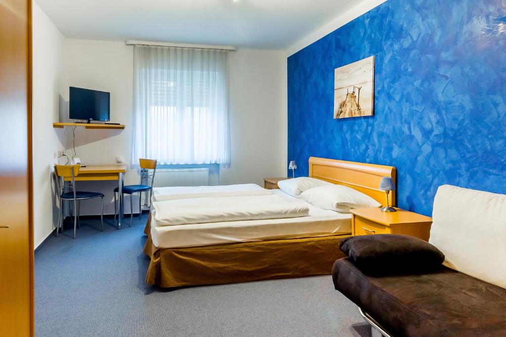 ein Hotelzimmer mit 2 Betten und einem Sofa in der Unterkunft Gasthof Alte Post in Falkendorf