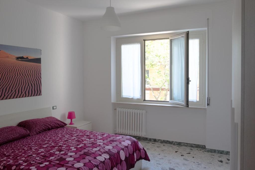 ein weißes Schlafzimmer mit einem Bett und einem Fenster in der Unterkunft Appartamento sul mare in Francavilla al Mare