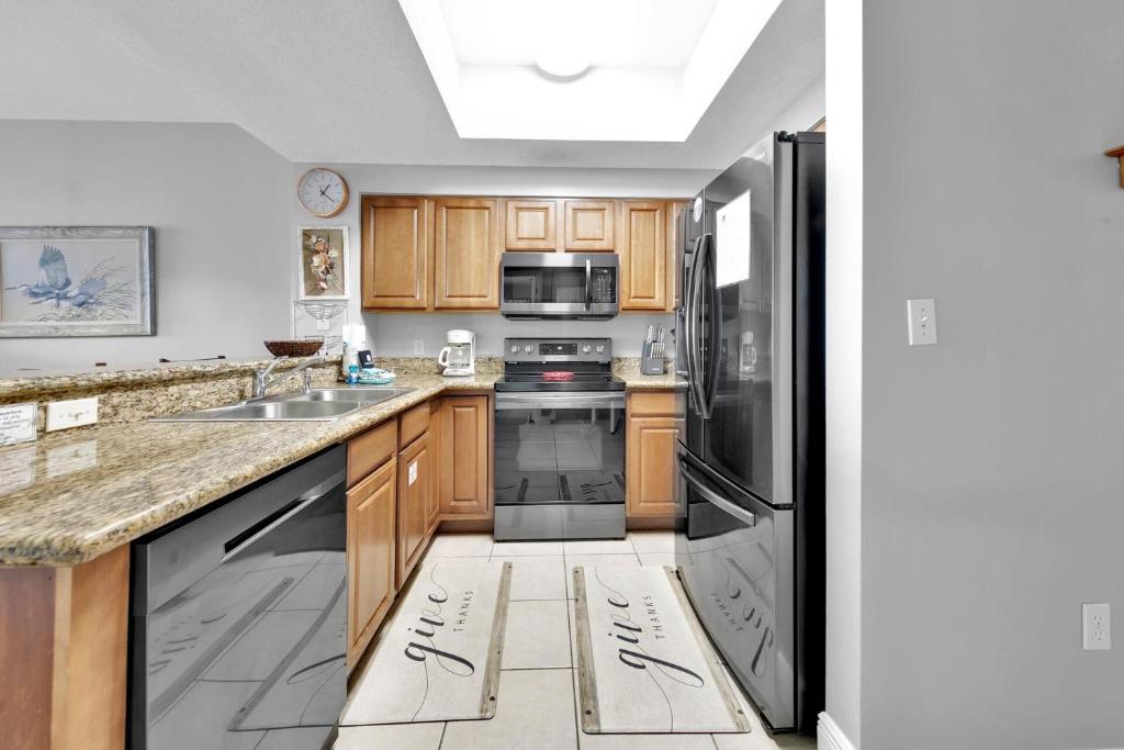 a kitchen with wooden cabinets and stainless steel appliances at Ariel Dunes I Unit 1209 Gulf view in Destin