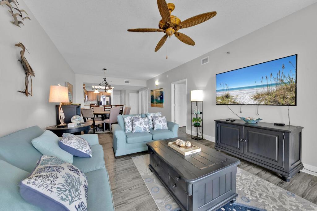 a living room with a blue couch and a ceiling fan at Ariel Dunes I Unit 1209 Gulf view in Destin