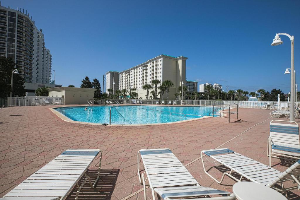 a swimming pool with lounge chairs and a building at Ariel Dunes I Unit 1209 Gulf view in Destin