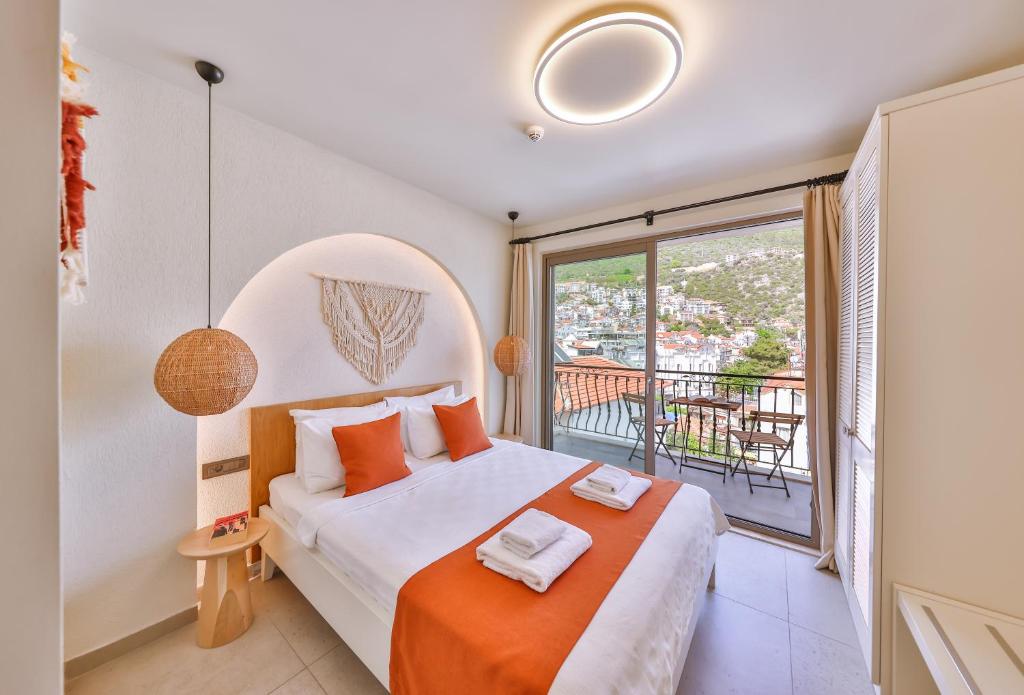 a bedroom with a bed and a balcony at Hotel Pastel Kaş in Kas