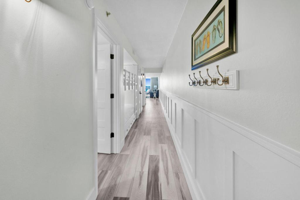 einen weißen Flur mit weißen Wänden und Holzböden in der Unterkunft Beautiful Updated Pelican Beach Unit!!! in Destin