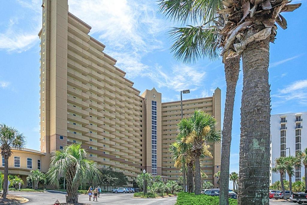 un grande edificio con palme di fronte di Beautiful Updated Pelican Beach Unit!!! a Destin