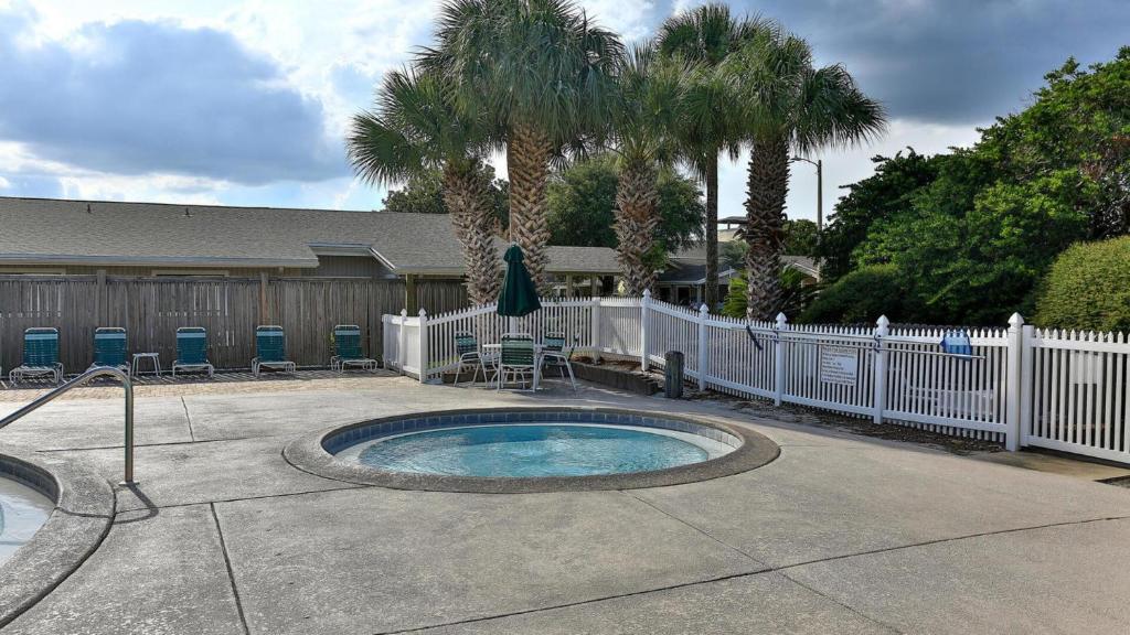 ein kleiner Pool in einem Hof mit Zaun und Palmen in der Unterkunft Cozy renovated ground floor unit - Golf Villa - on the Golf Course in Destin