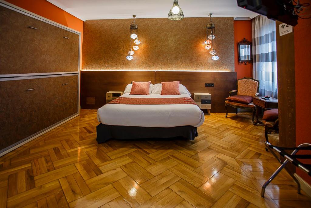 a hotel room with a bed and a chair at Hostal Rodas Pamplona in Pamplona