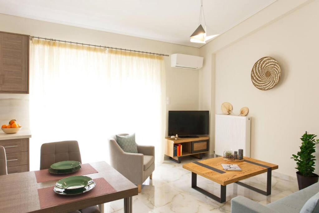 een woonkamer met een tafel en een televisie bij Sunny Apartment Lefkada - Lefkada BnB in Lefkada