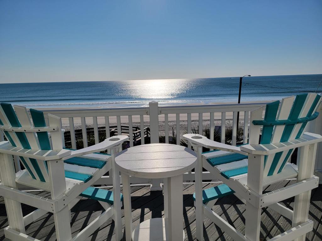 two chairs and a table on the beach at SEArenity in Surf City