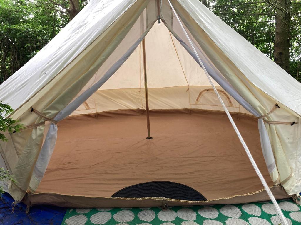 een canvas tent met een gat in het midden bij WoodLands Basic Bell Tent 3 in Grantham