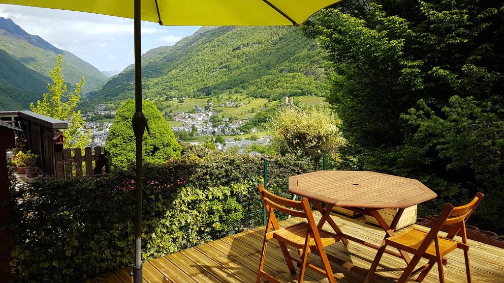 une table et des chaises sur une terrasse avec un parasol dans l'établissement Le chalet de Luz avec terrasse & vue sur la vallée, à Luz-Saint-Sauveur