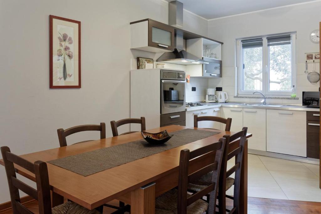 kuchnia z drewnianym stołem i jadalnią w obiekcie Apartment Maritea by Rent Istria w mieście Umag