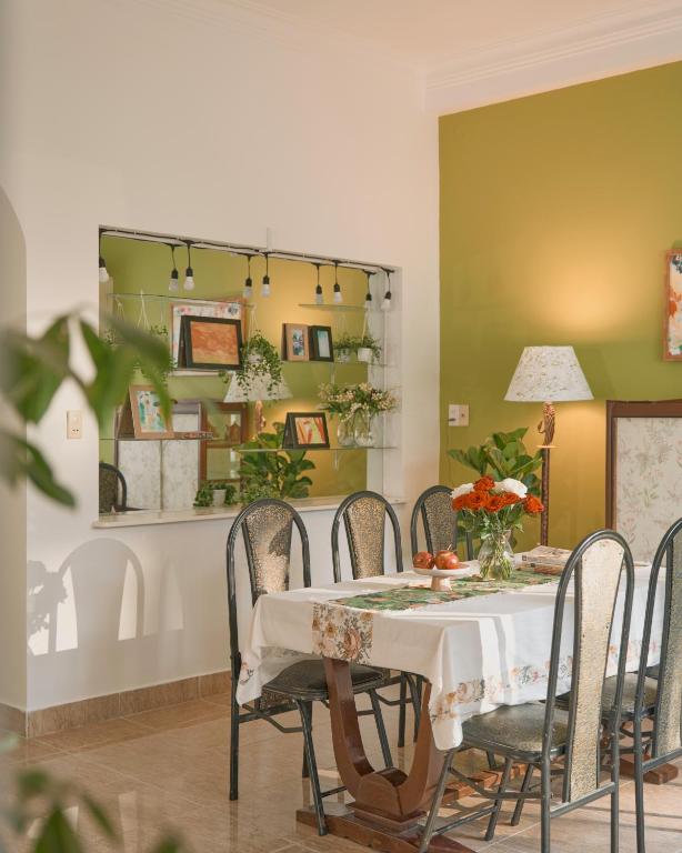a dining room with a table with chairs and a mirror at Oliu Home Đà Lạt in Xuan An