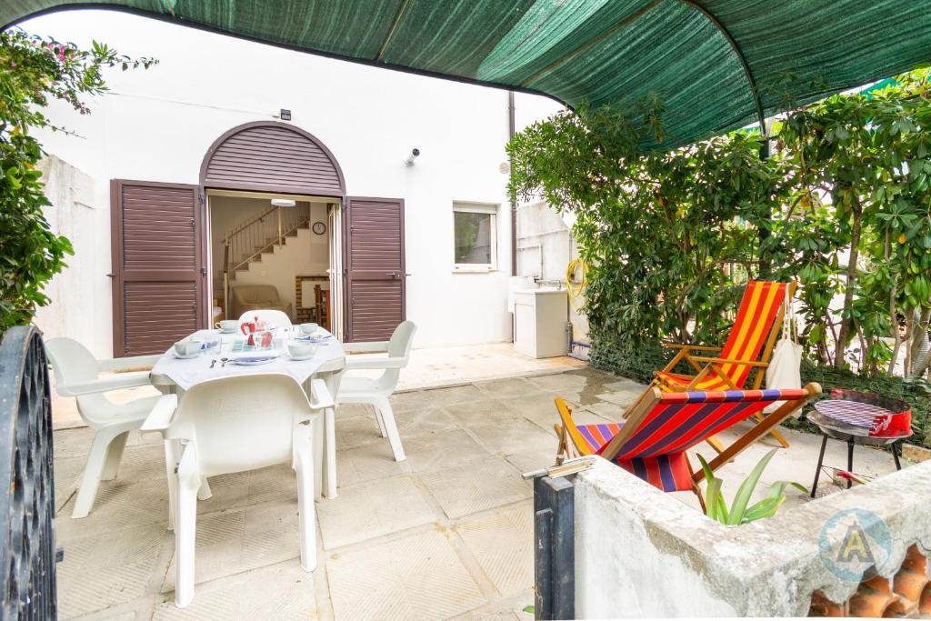 a patio with a white table and chairs at Villetta a schiera nella Pineta di Silvi Marina in Silvi Marina