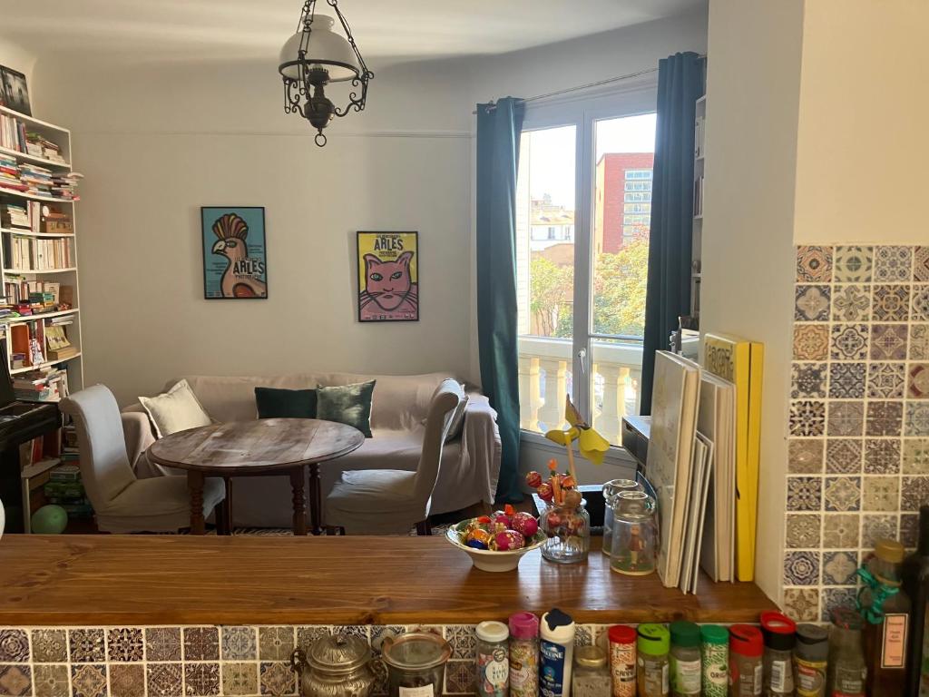 a living room with a table and a couch at Appartement chateau de Vincennes JEUX OLYMPIQUES in Vincennes