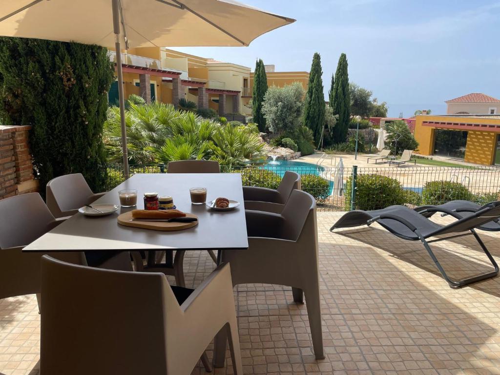 a table and chairs and an umbrella on a patio at No14 Lote B, Quinta da Belavista in Luz
