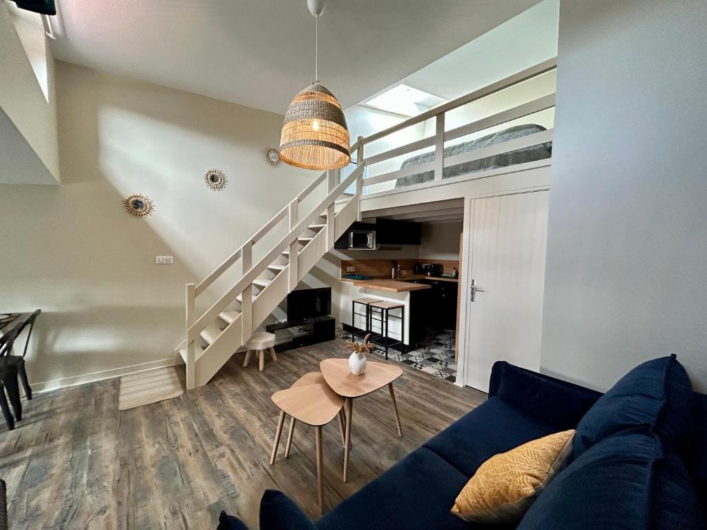 un salon avec un canapé bleu et une table dans l'établissement Votre duplex en hypercentre !, à La Rochelle