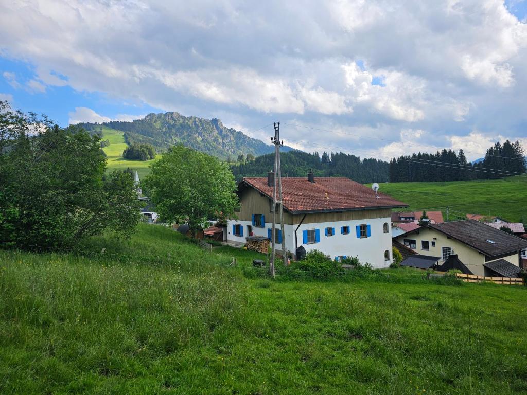 a white house on a hill with a green field at Jungholz Erlebnis in Jungholz