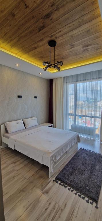 a bedroom with a large bed with a wooden ceiling at Токио 3 in Astana