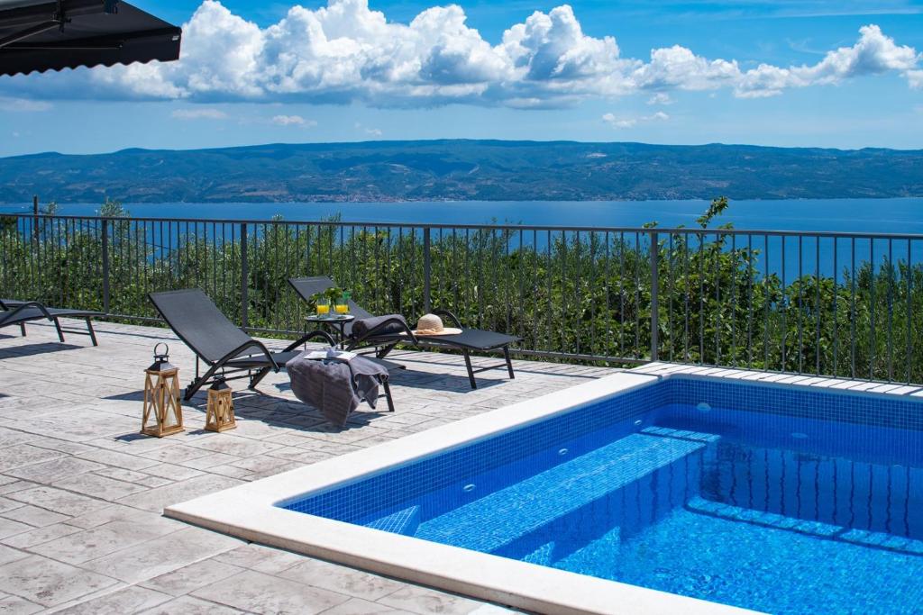 a swimming pool with a view of the water at Seaview Villa Roko in Sumpetar