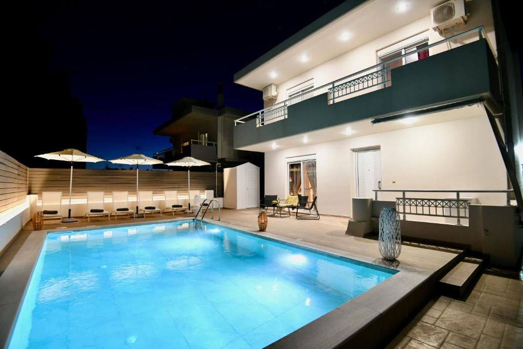 a swimming pool in front of a house at night at Angels Villa in Kremasti