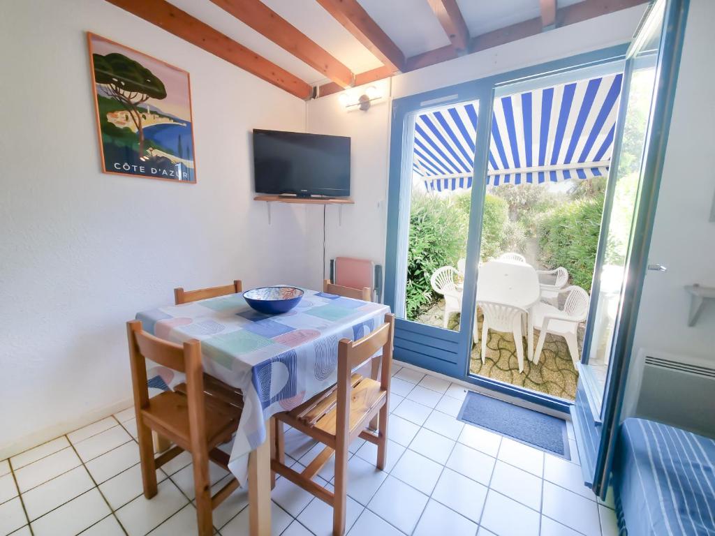 une salle à manger avec une table et un balcon dans l'établissement Escale Azur - Mazet avec jardin, wifi, piscine, au Lavandou