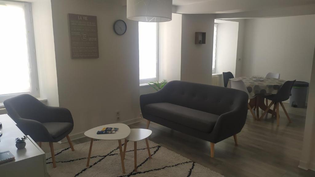 un salon avec un canapé et une table dans l'établissement Cœur de Ville Yffiniac, à Yffiniac