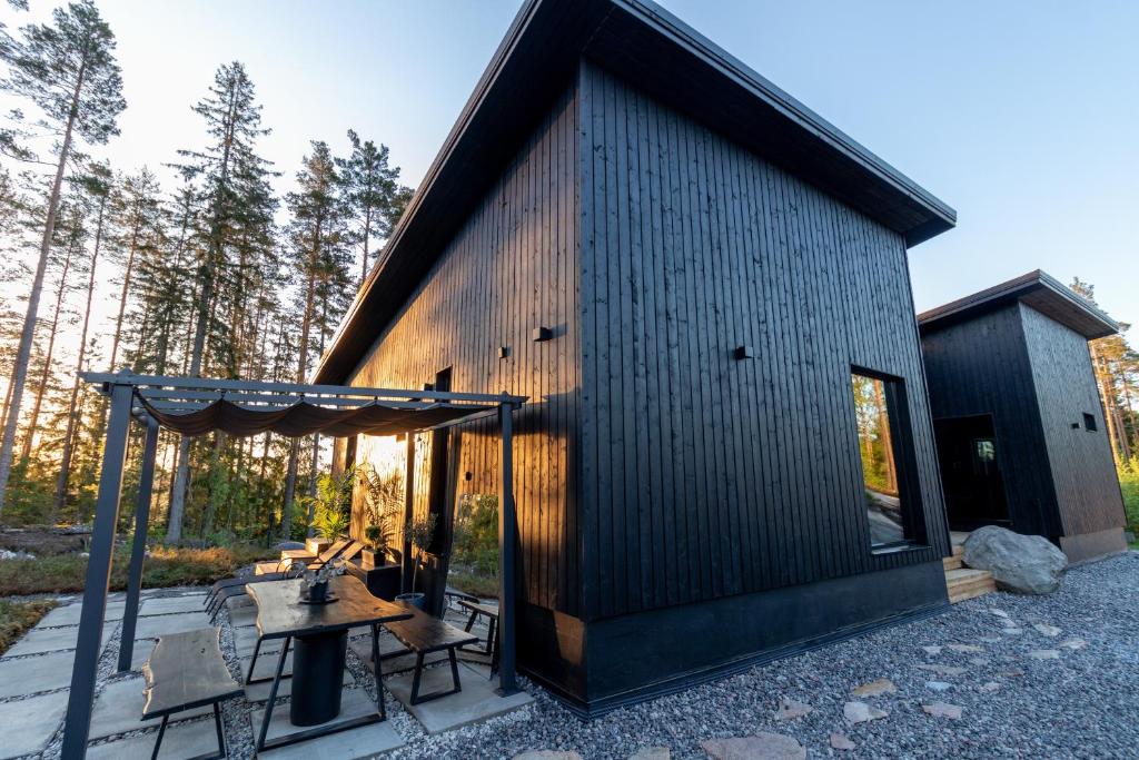 SöderkullaVilla Blackwood的前面设有一张野餐桌的黑色小小屋