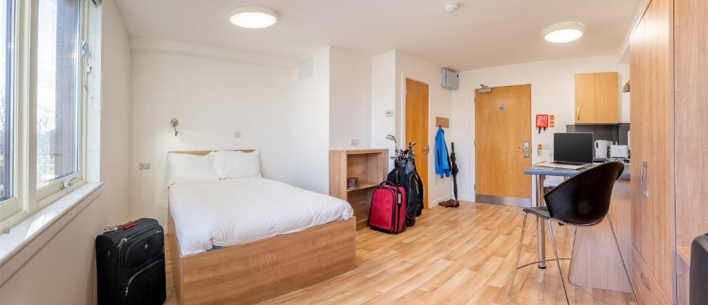 a bedroom with a bed and a desk with a computer at UHI Inverness - Campus Accommodation in Inverness