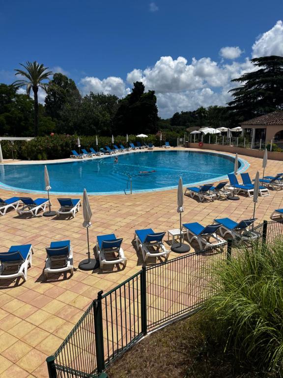 une piscine avec chaises longues et parasols dans l'établissement Appartement Résidence 