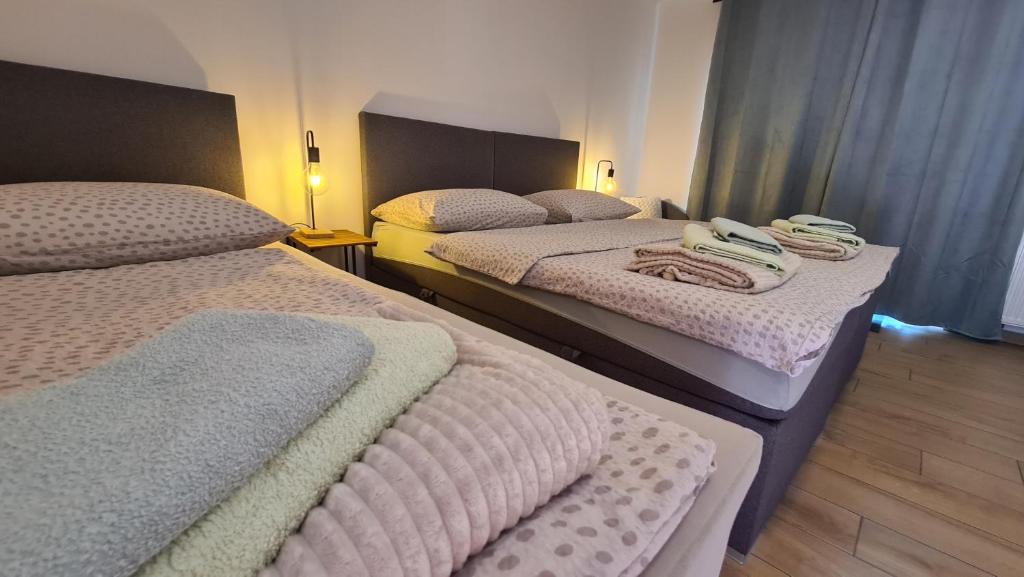 two beds in a hotel room with towels on them at Brne Rooms in Postojna