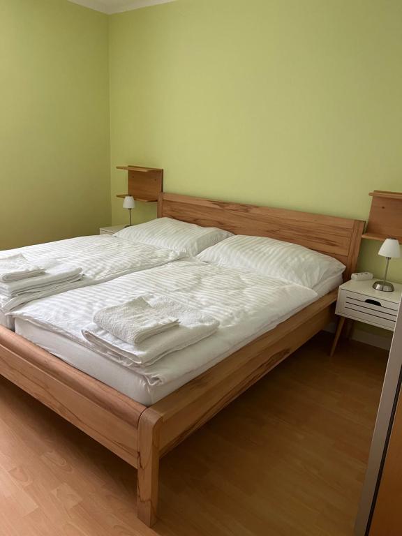 ein Schlafzimmer mit einem großen Bett mit weißer Bettwäsche in der Unterkunft Eisenerz Alpine Apartement RoSy in Eisenerz