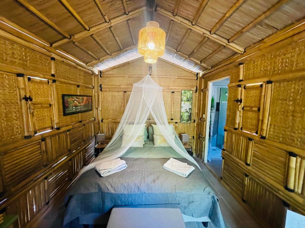 a bedroom with a bed with a mosquito net at Suite Bambou Bien-être à Bali - Le soleil des Cévennes in Saint-Jean-du-Gard