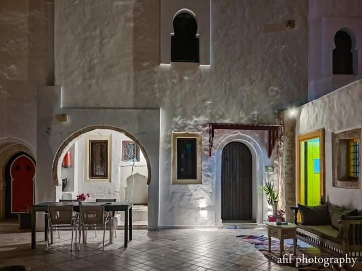 um quarto com uma mesa e cadeiras num edifício em Maison Leila chambres d hotes em Midoun